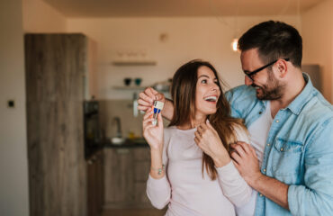 Young man surprising his wife or a girl with new a apartment.